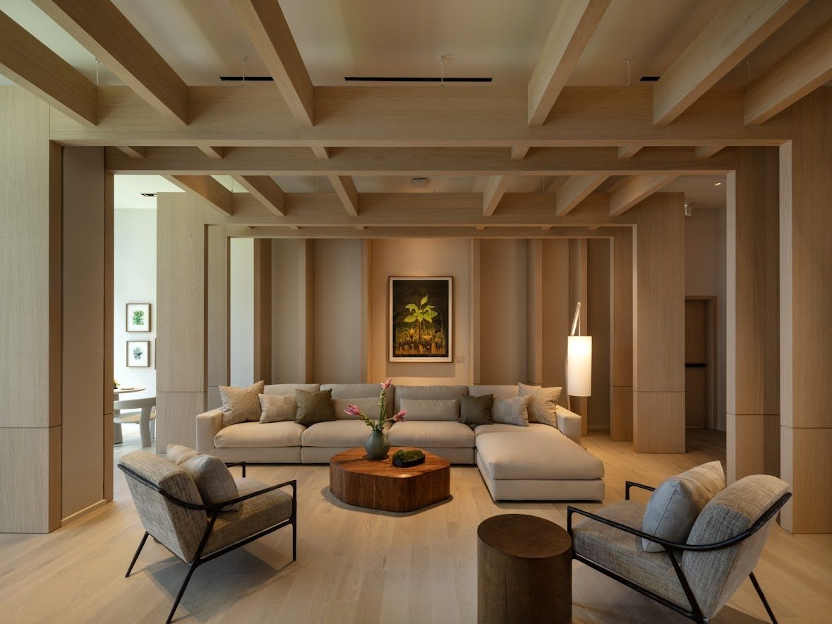 A modern living room with a large sectional sofa, a coffee table, and a painting on the wall.